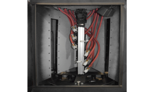 A metal enclosure with multiple red tubing lines connected to valves and a central vertical metal rod, viewed from above, likely part of automation-ready sandblast cabinets used in industrial or laboratory equipment.